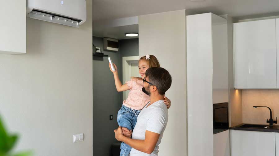 Father holds daughter while she turns on heat pump
