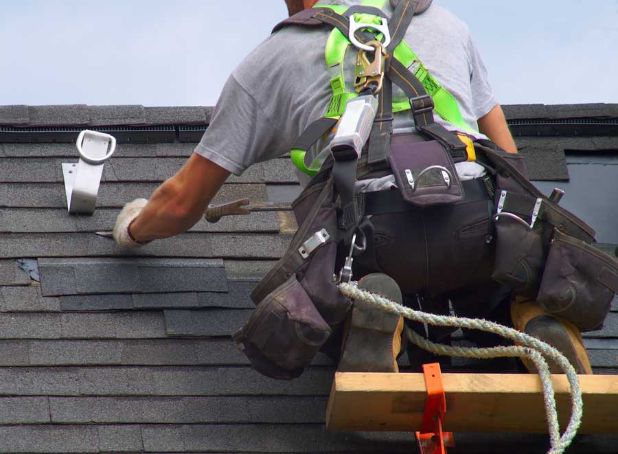 A construction worker fixes a roof