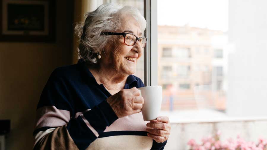 An older woman drinking a cup of tea