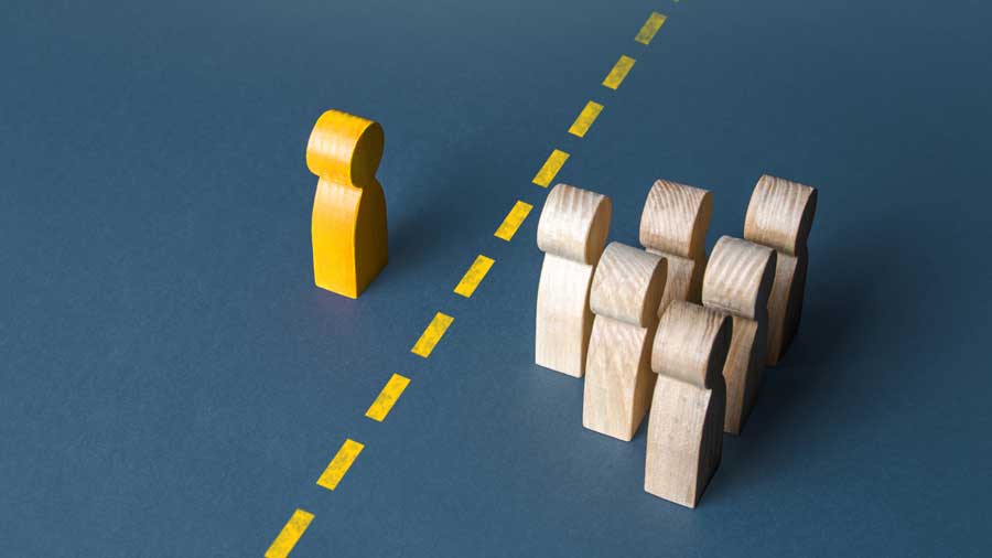 A wooden figure is separated from the group by a line