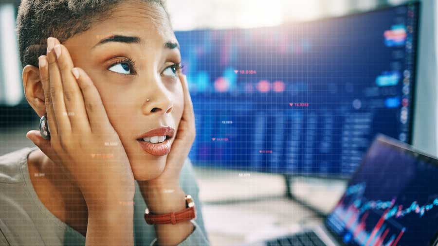 Stressed woman looks at data on a computer screen