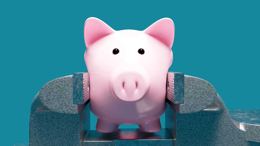 A piggy bank being squeezed in a vice