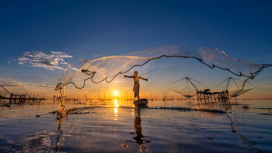 Silhouette of fisherman cast their nets
