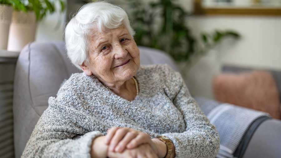 An older woman sits in an armchair