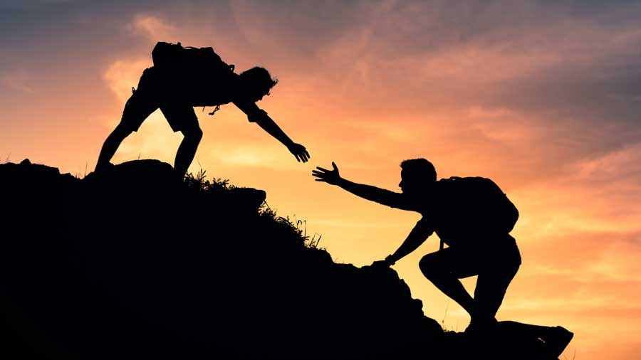Hiker helps fellow walker up a hill