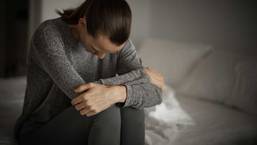 Sad woman sitting on a bed