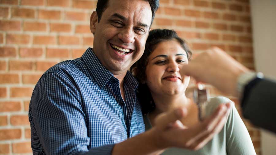Happy couple being given keys to their new home