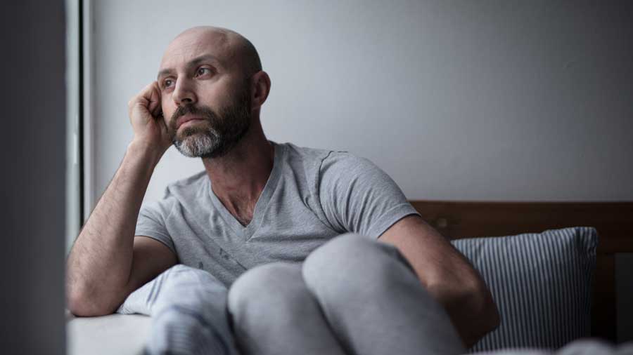 A sad man looks out of a window