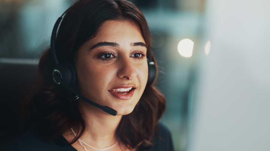 A customer service worker talks on a headset
