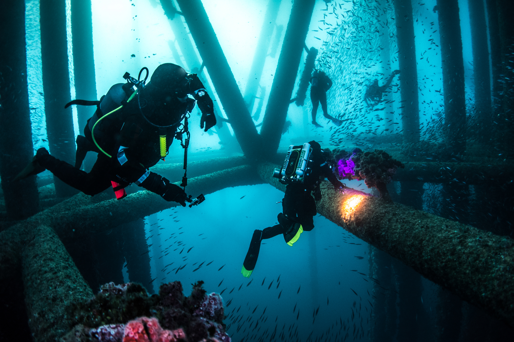 scuber divers on an oil rig