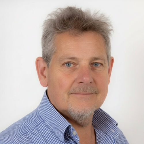 Man in blue shirt smiling at camera.