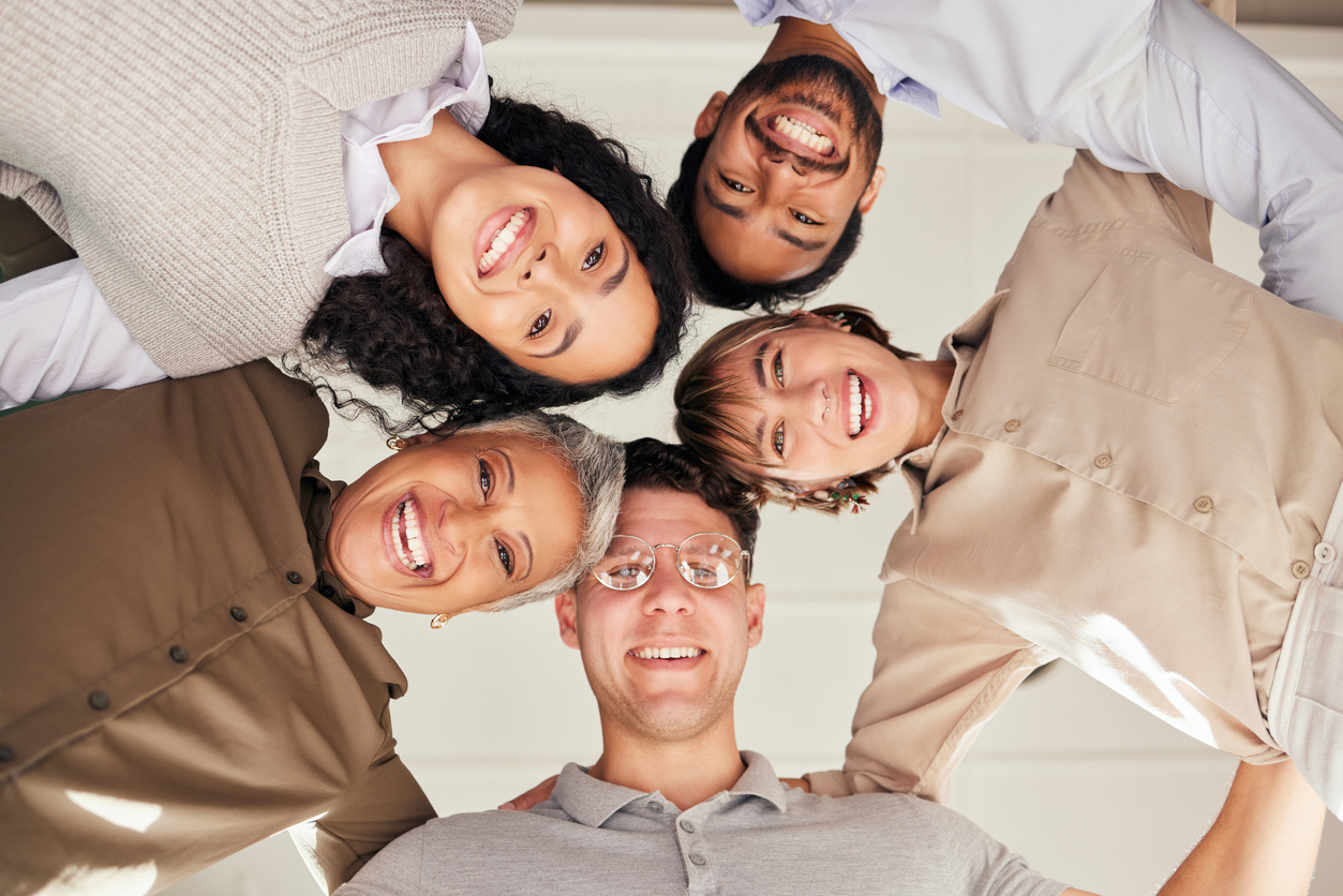 Meeting, portrait or happy business people in huddle with goals, support or motivation for success. Low angle of faces, team work or employees planning our vision, sales target or mission stock photo