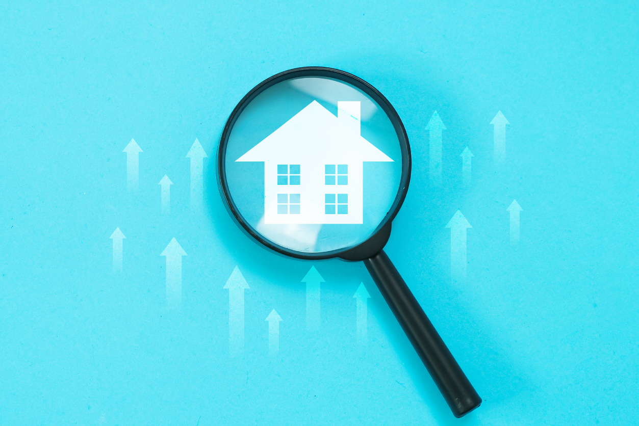 Magnifying glass focus on house sign with arrow pointing up concept of Increase in Value and Real Estate Taxes. stock photo