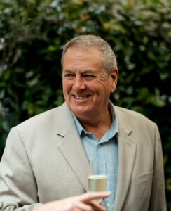 Colin Sherrif smiling in a white suit jacket